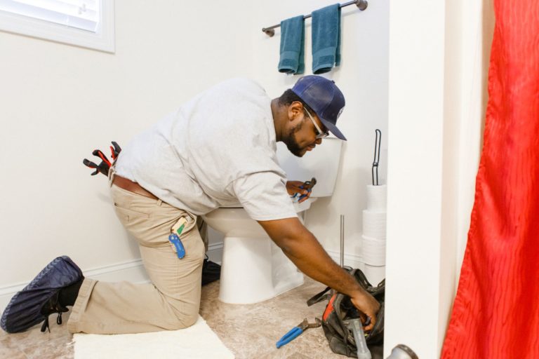 Meetze Plumbing technician repairing toilet