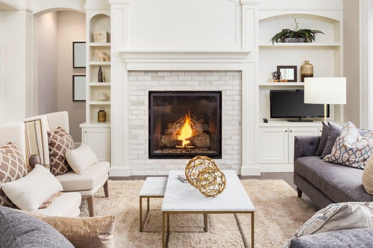A cozy and modern living room with a lit gas log fireplace