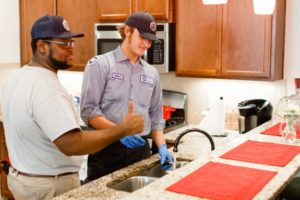 Meetze Plumbing technician giving thumbs up while standing at kitchen sink