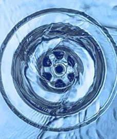 closeup image of water swirling down a drain