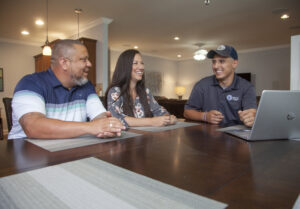 People discussing plumbing services at a dining table.