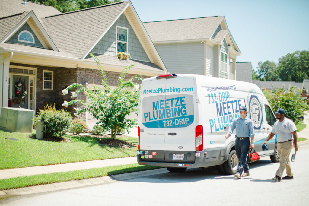 Meetze Plumbing Experts Walking Toward House